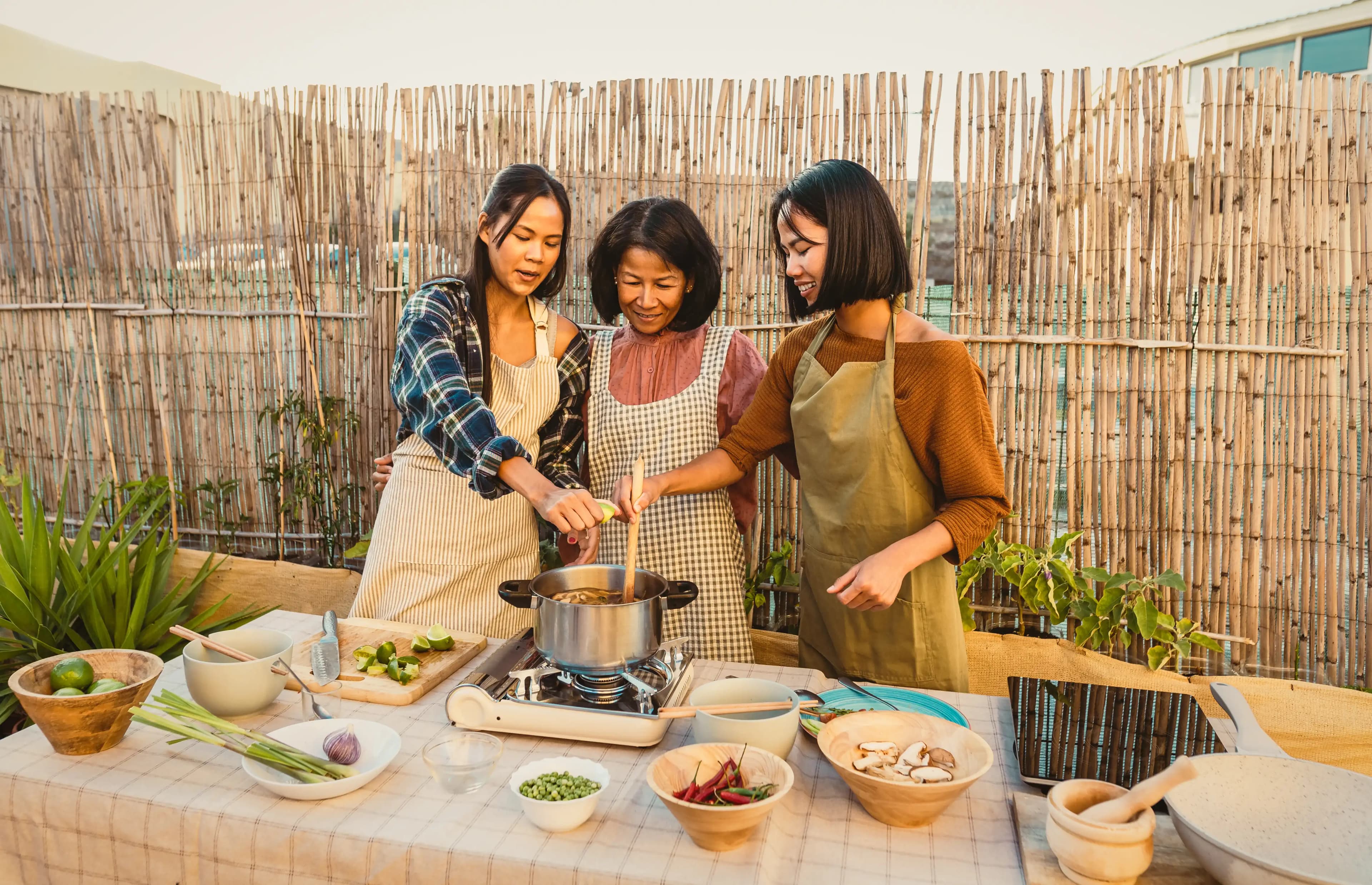Happy Thai family having fun preparing soup recipe together